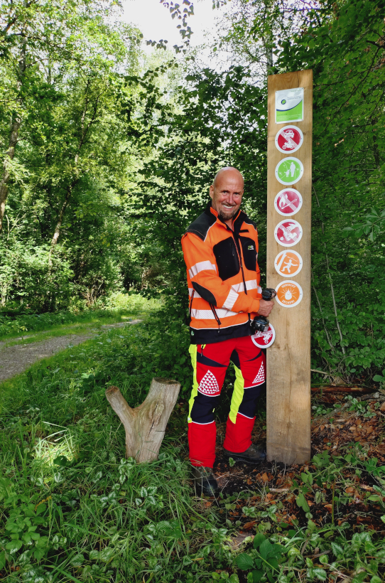Thomas Schulz von den SHLF bringt in der Försterei Drage ein Piktogramm an der Waldeingangsbeschilderung an c SHLF